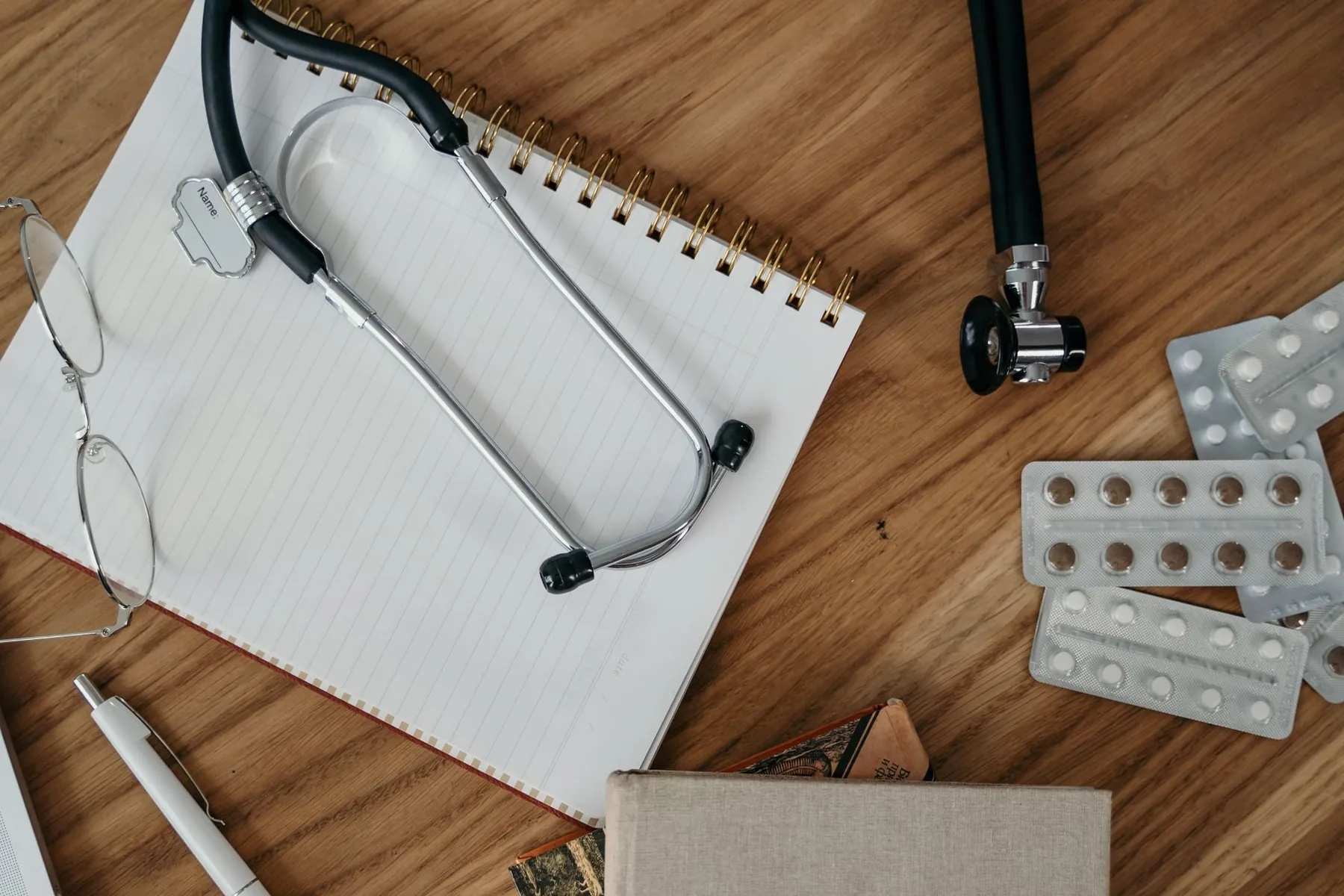 A notepad and glasses on a desk, illustrating the questions to bring to a consultation.