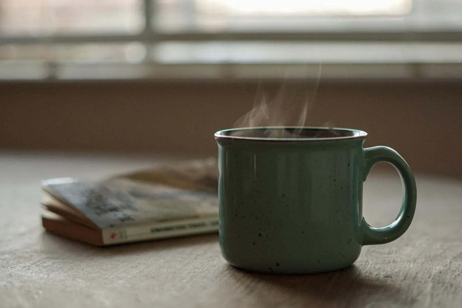 A cup of tea and a book on a table, illustrating the quiet days recovery involves.