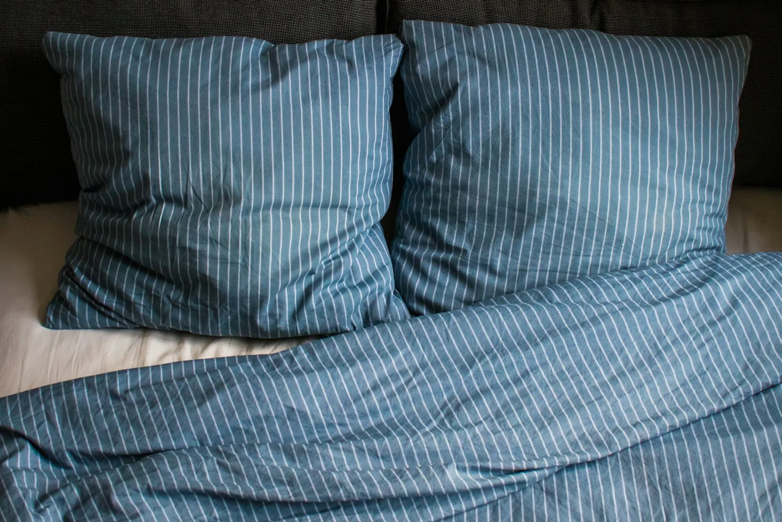 Pillows on a made bed, illustrating sleeping propped up as instructed after surgery.