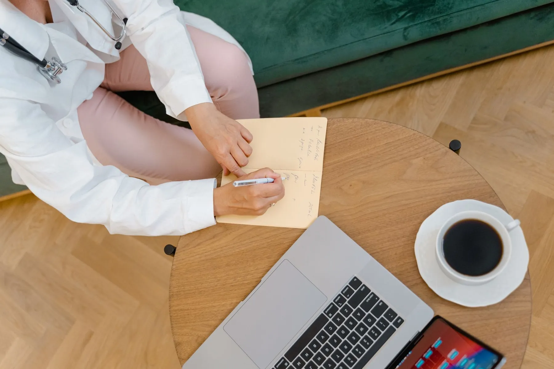 A stethoscope and notebook on a desk, illustrating checking a surgeon's credentials.