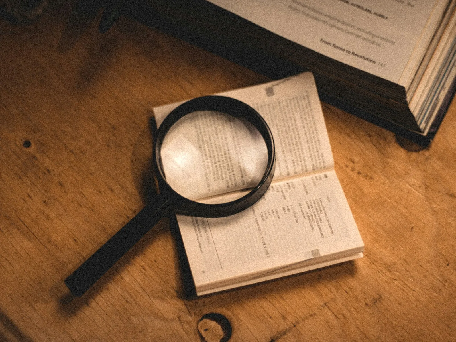 A document examined under a magnifier, illustrating verifying credentials.