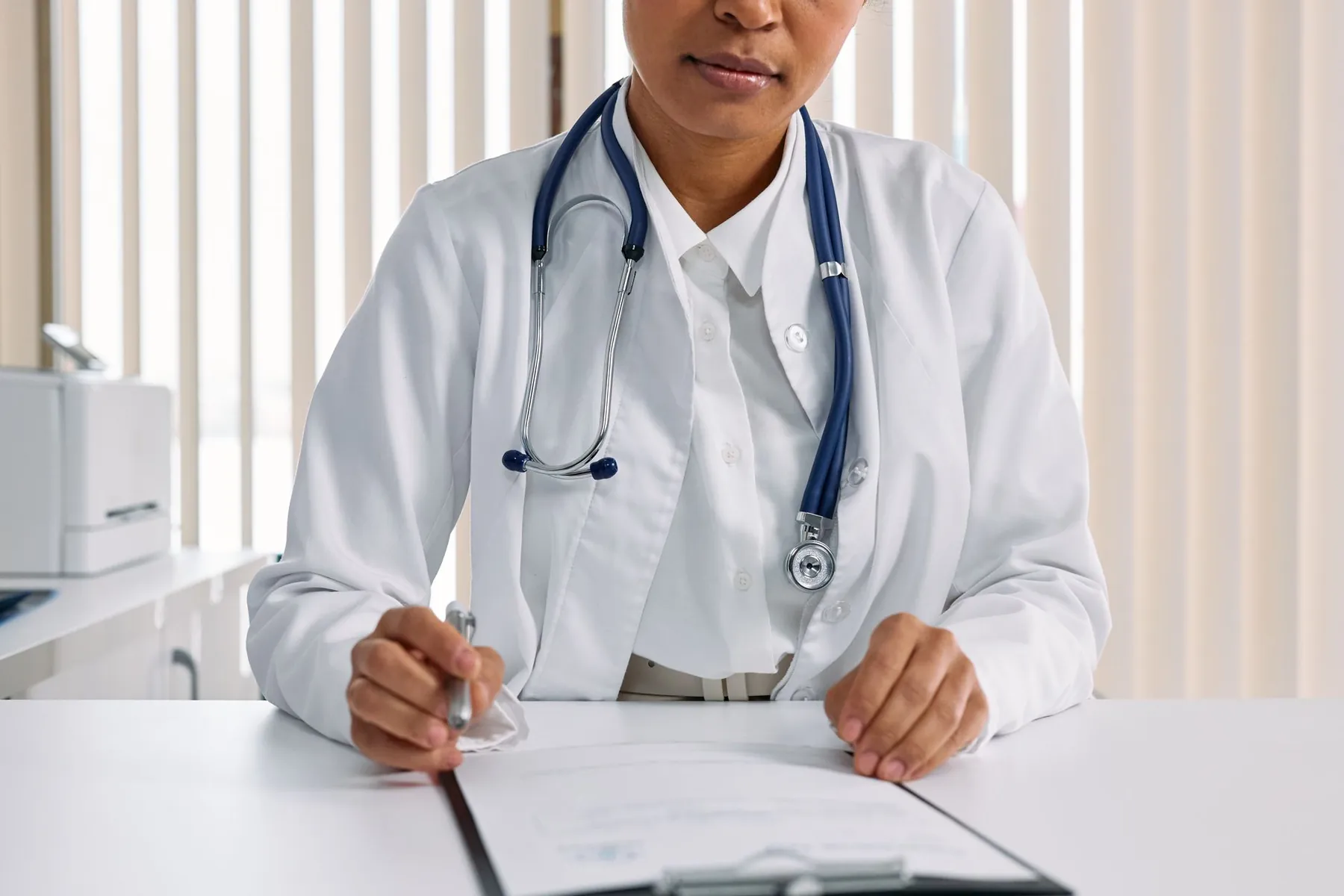 Notes being written at a desk, illustrating the medical history taken at a consultation.