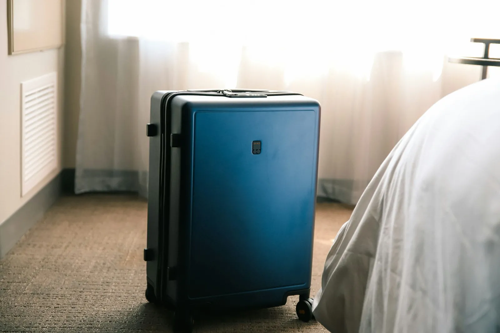 A suitcase in a hotel room, illustrating a trip planned around surgery.