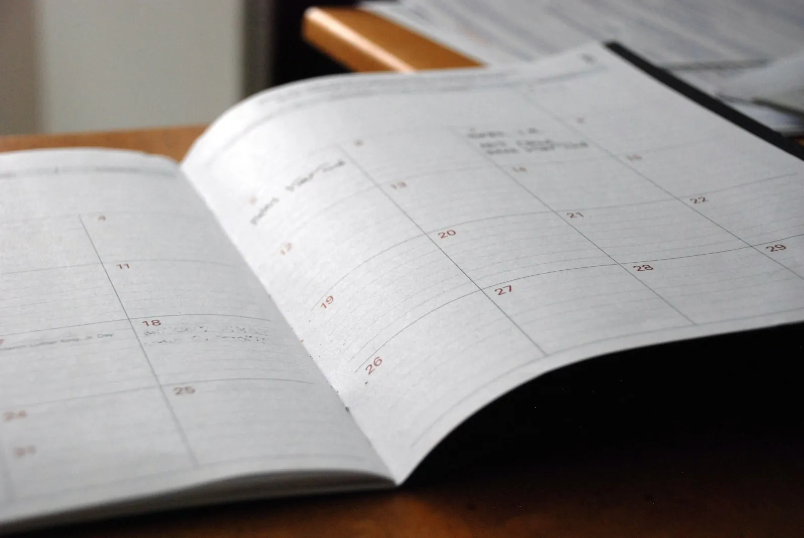 A calendar on a plain desk, illustrating recovery measured in stages rather than a single date.