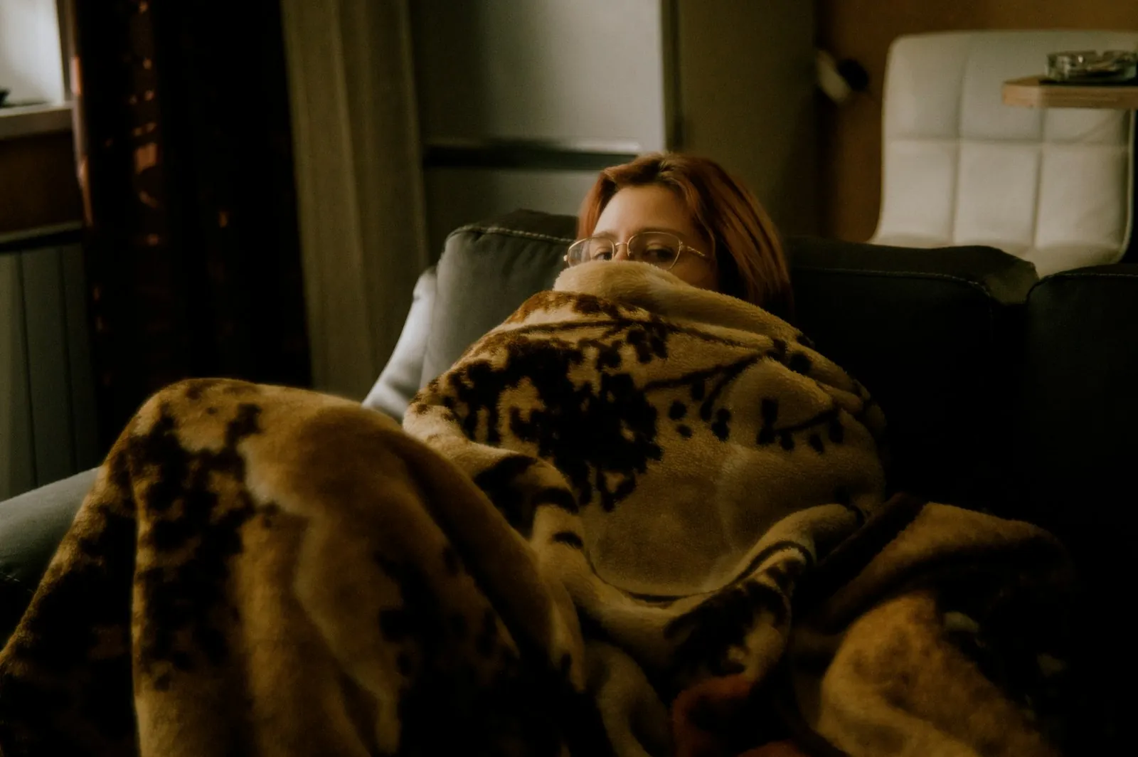 A quiet chair with a blanket in daylight, illustrating rest during the first week after surgery.