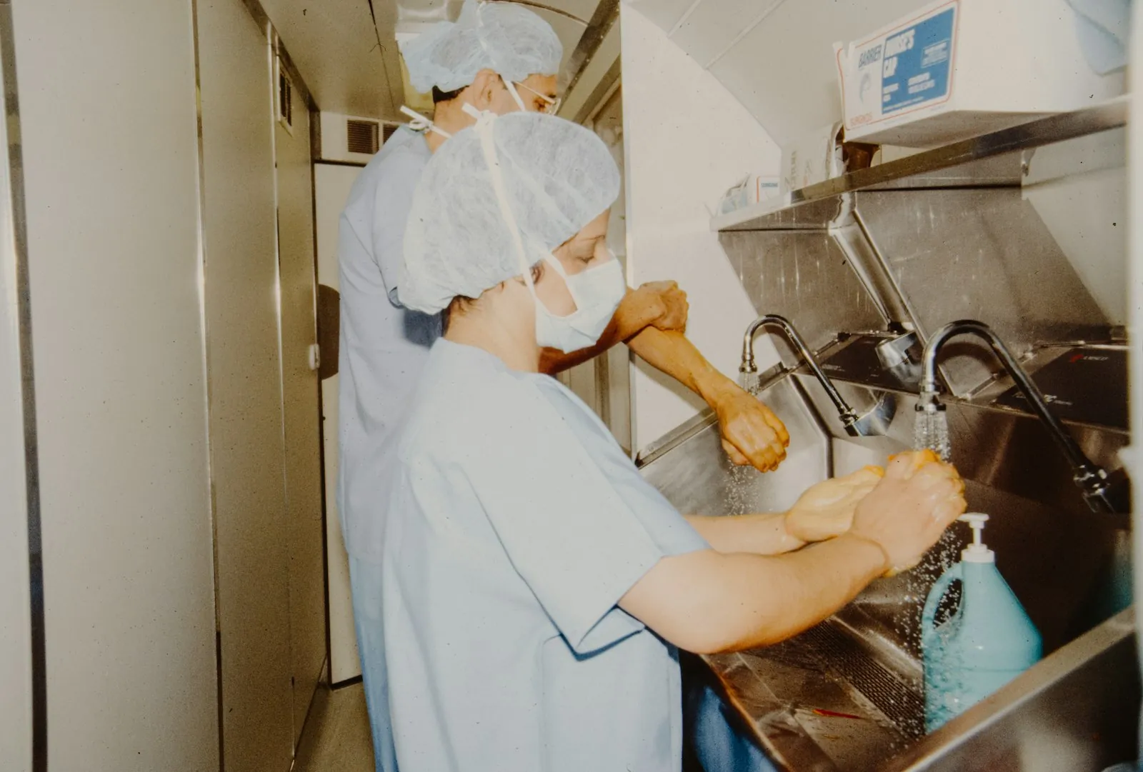 Surgical hand washing at a sink, illustrating the routines that underpin surgical safety.