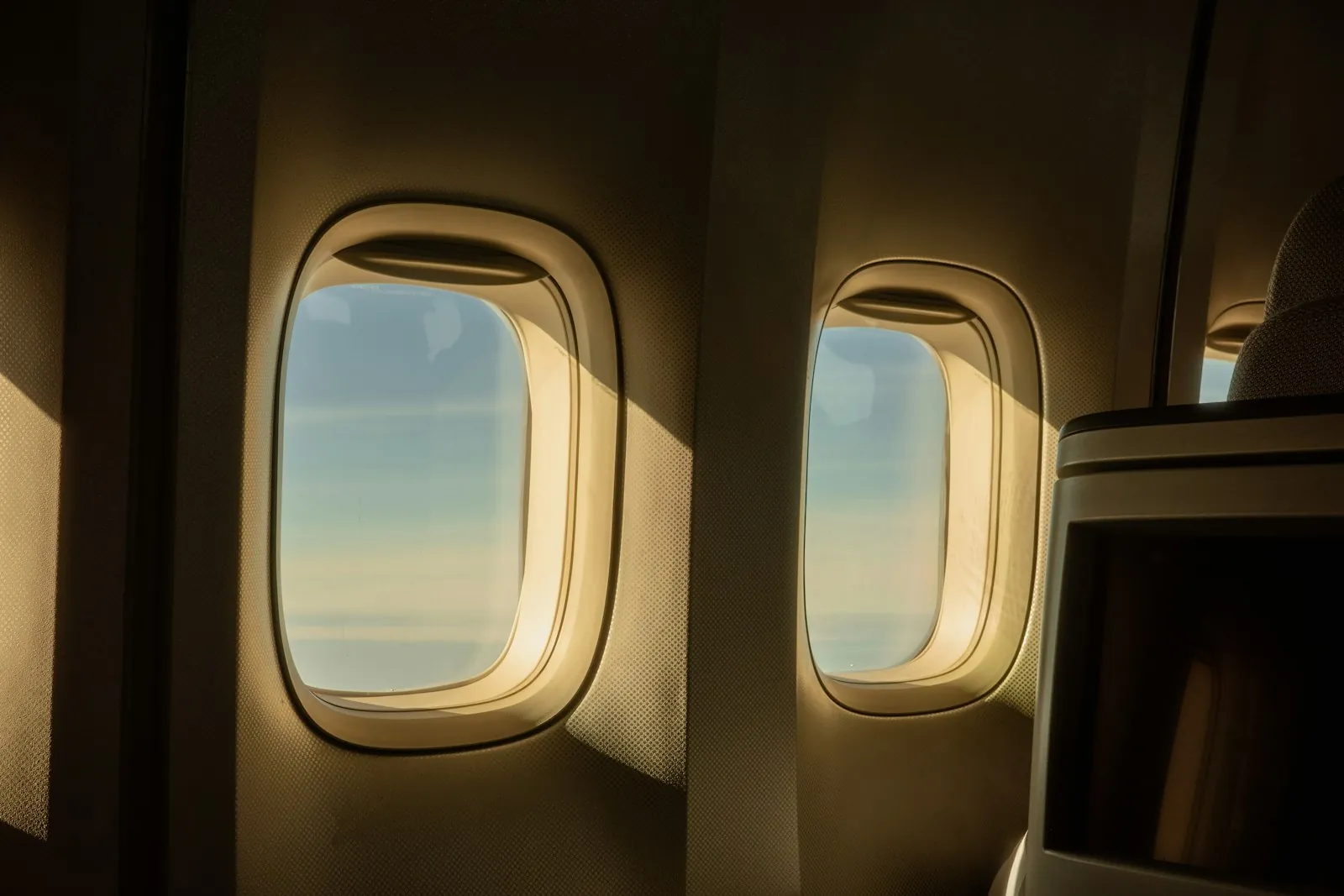 A passenger at a window seat, illustrating a long flight home.