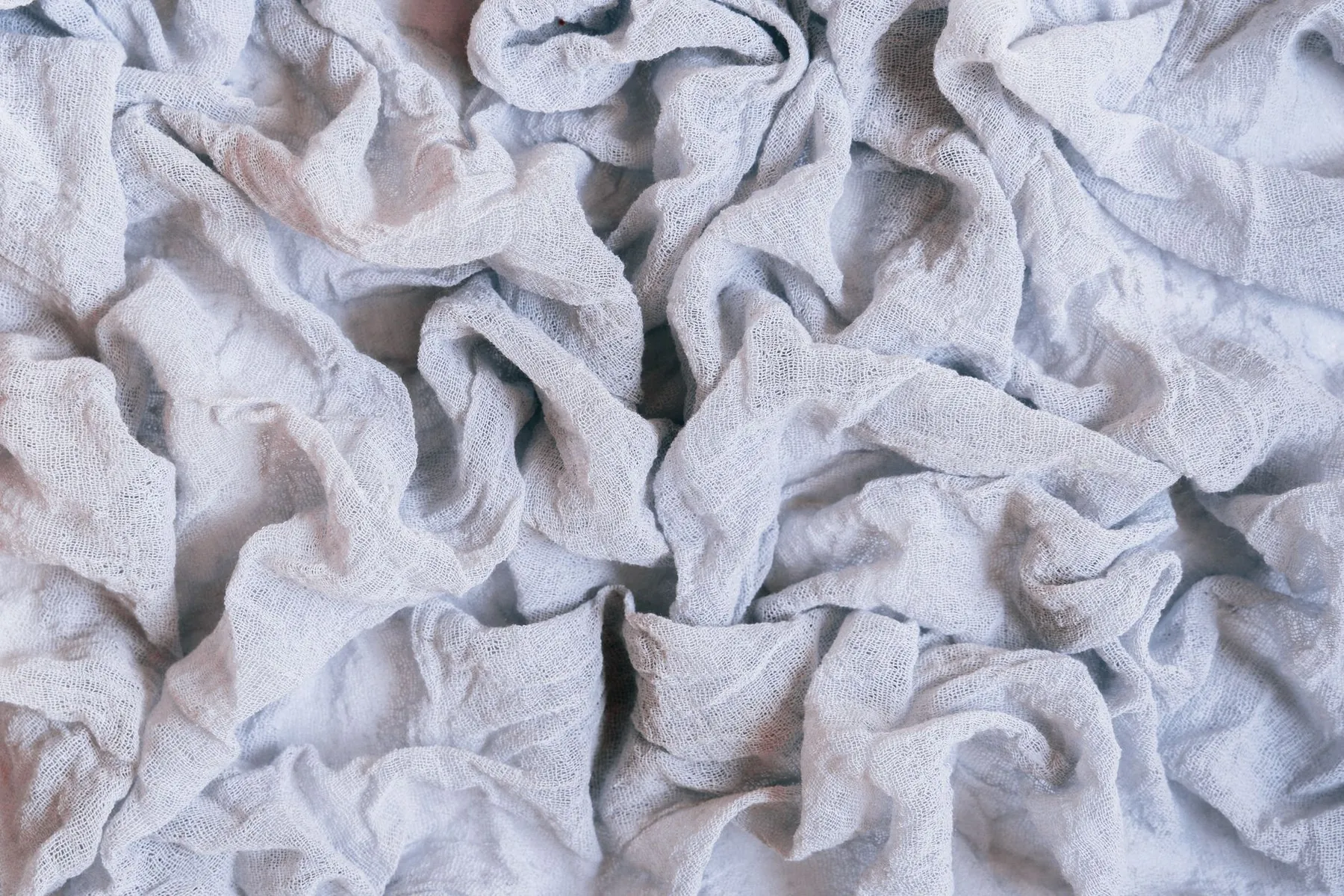 Creased linen, illustrating skin that drapes rather than retracting after volume is removed.