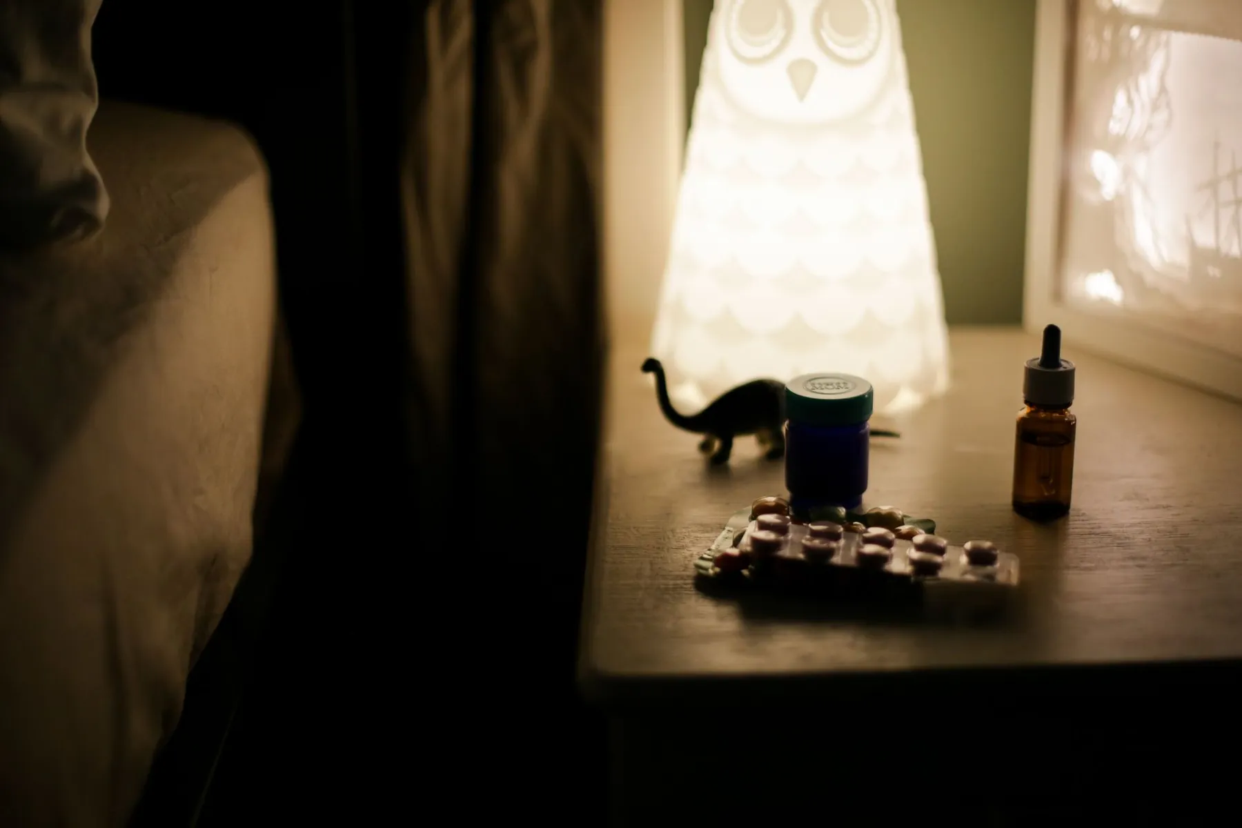 Lubricating drops on a bedside table, illustrating managing dryness.