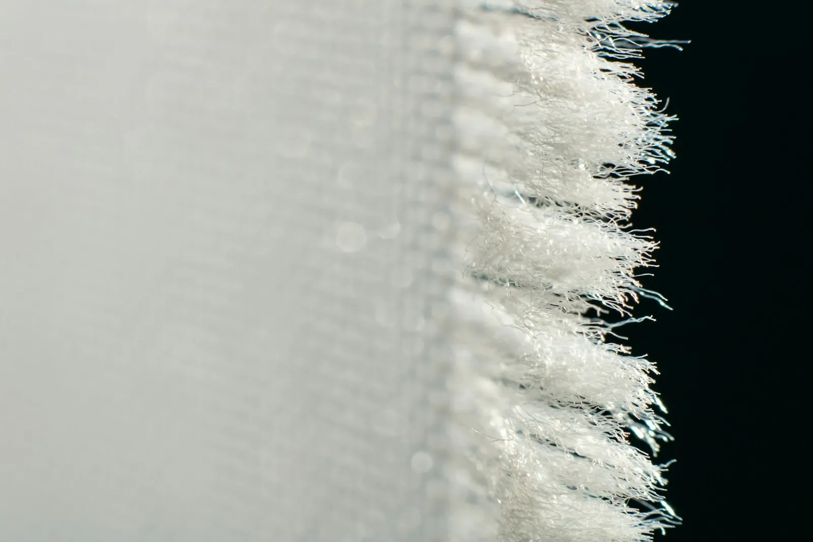 Fabric pulled taut at an edge, illustrating tension on a lower lid.