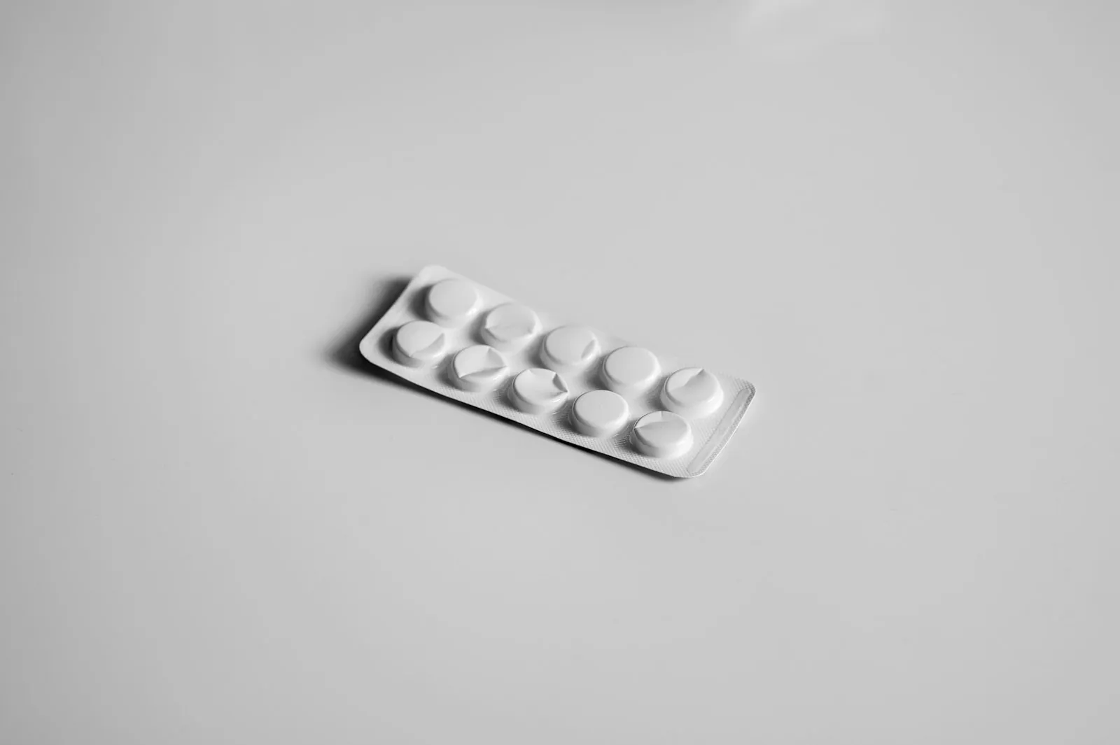 Medicines on a plain surface, illustrating the medication list to bring to a consultation.