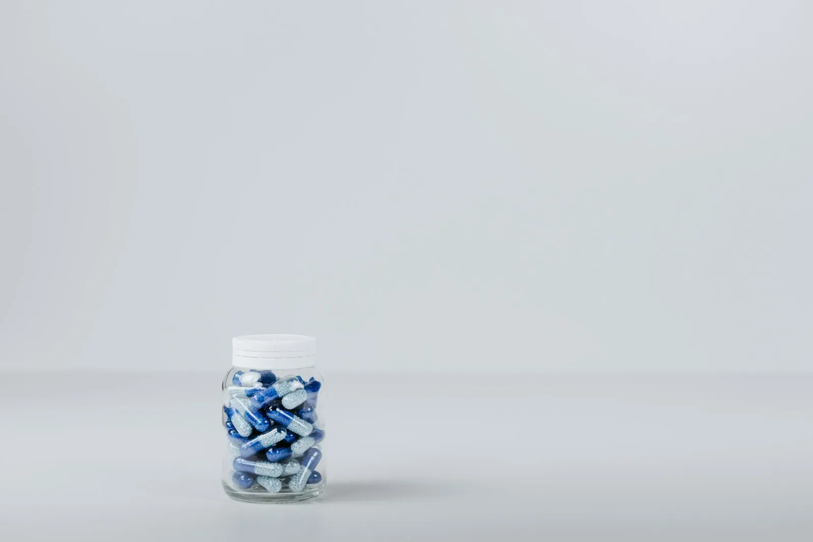 Medicines arranged on a plain surface, illustrating bringing medication in original packaging.