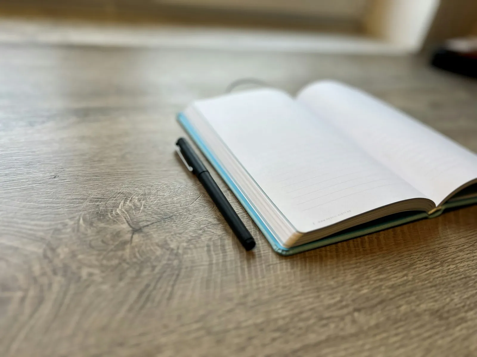 A notebook and pen on a desk, illustrating an article about preparing for a consultation.