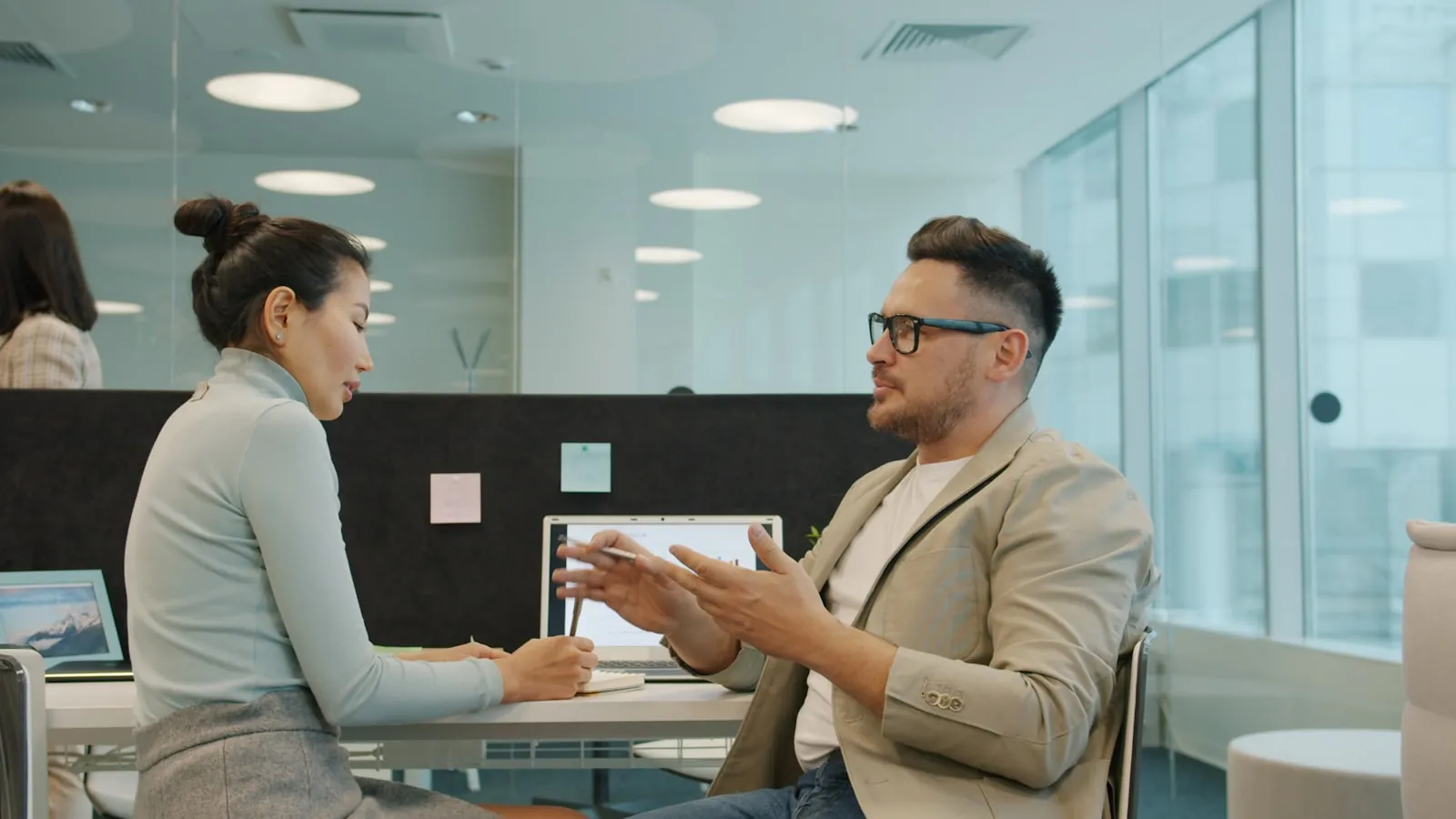Two people talking across a table, illustrating an article about questions to ask a surgeon.