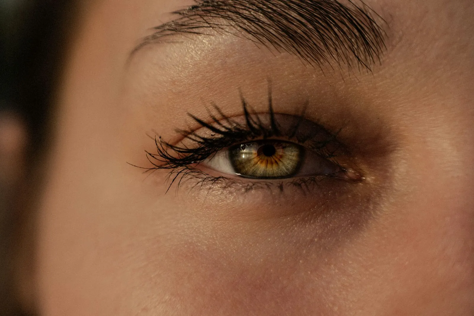 A close view of a person's eye and upper eyelid in soft daylight. An illustrative photograph: not a patient of this practice, and not a depiction of results.