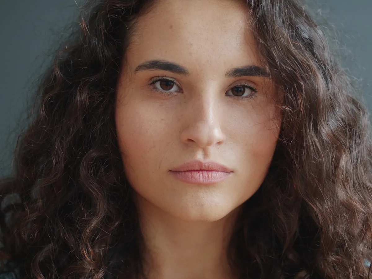 A calm, natural portrait in soft daylight. An illustrative photograph: not a patient of this practice, and not a depiction of results.
