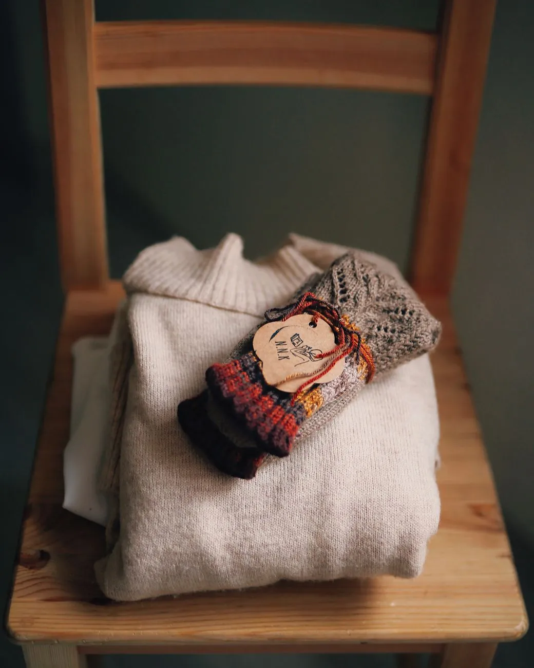Folded clothing on a chair in soft daylight.