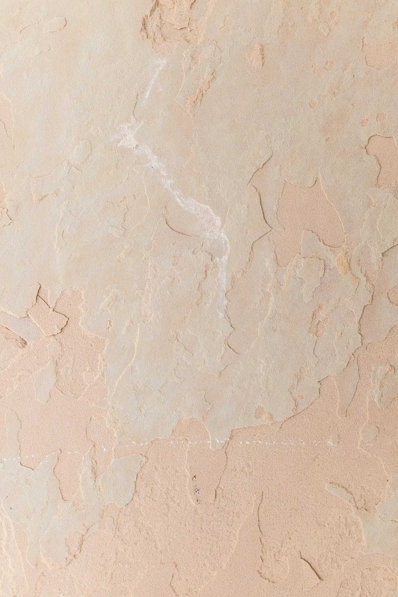 A pale stone wall in soft natural light.