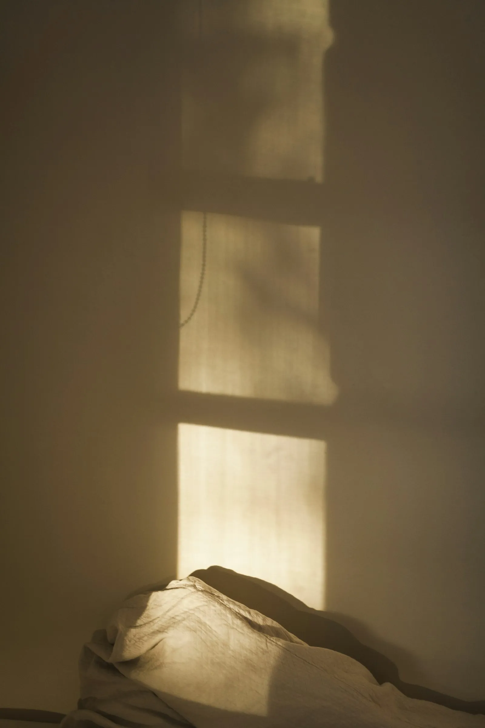 Daylight through a linen curtain in a quiet interior.