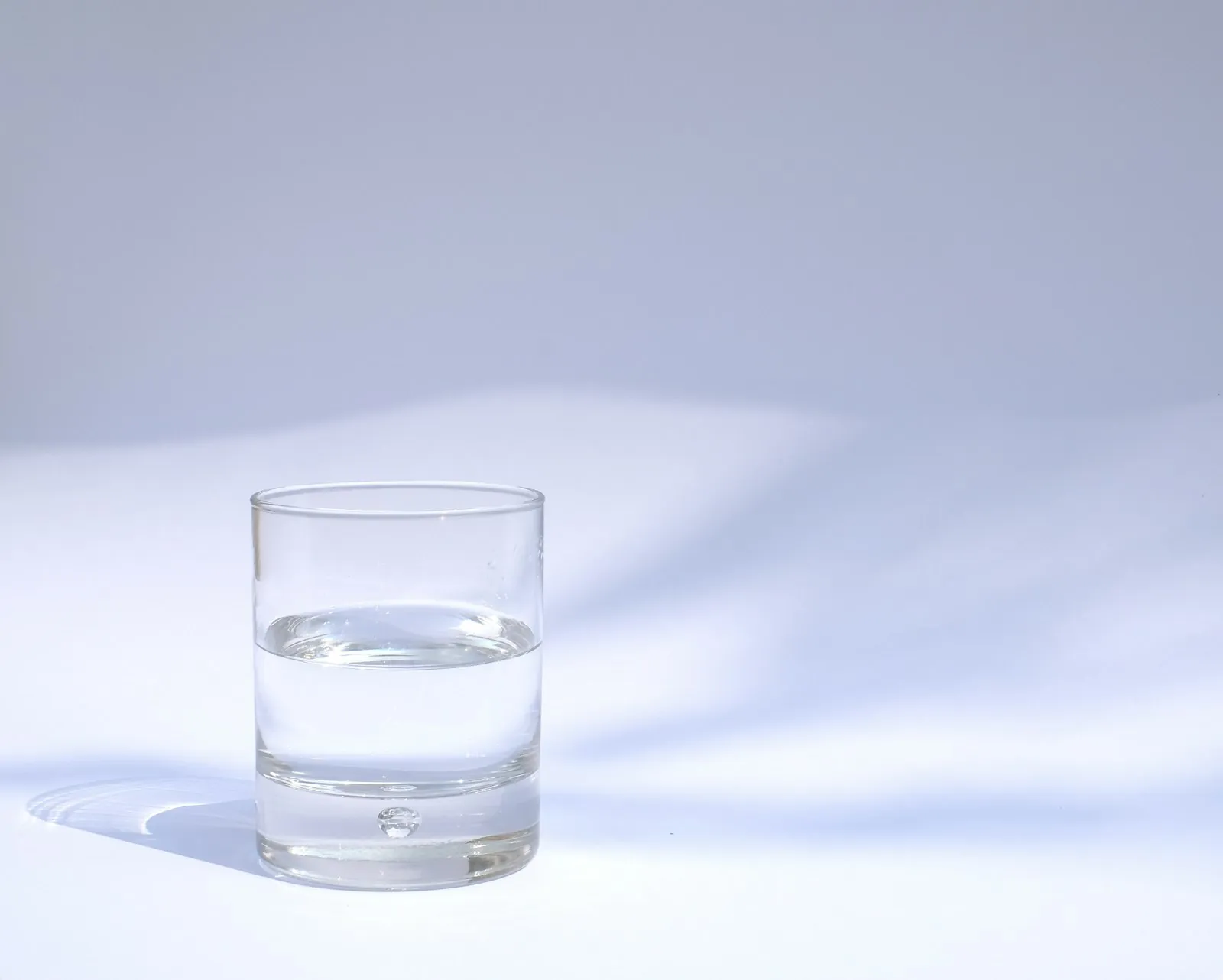 Water being poured into a glass, illustrating the importance of drinking more in a hot climate.