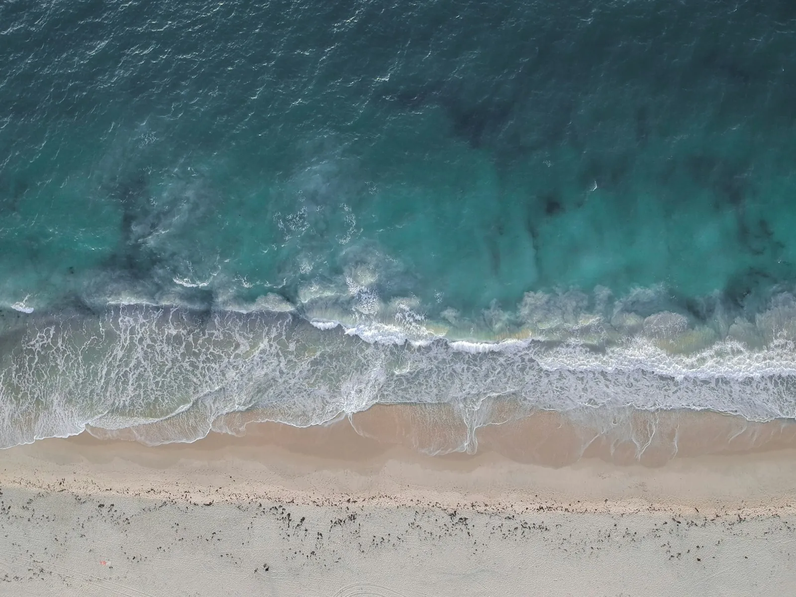An aerial view of a tropical coastline, illustrating travelling abroad for surgery.