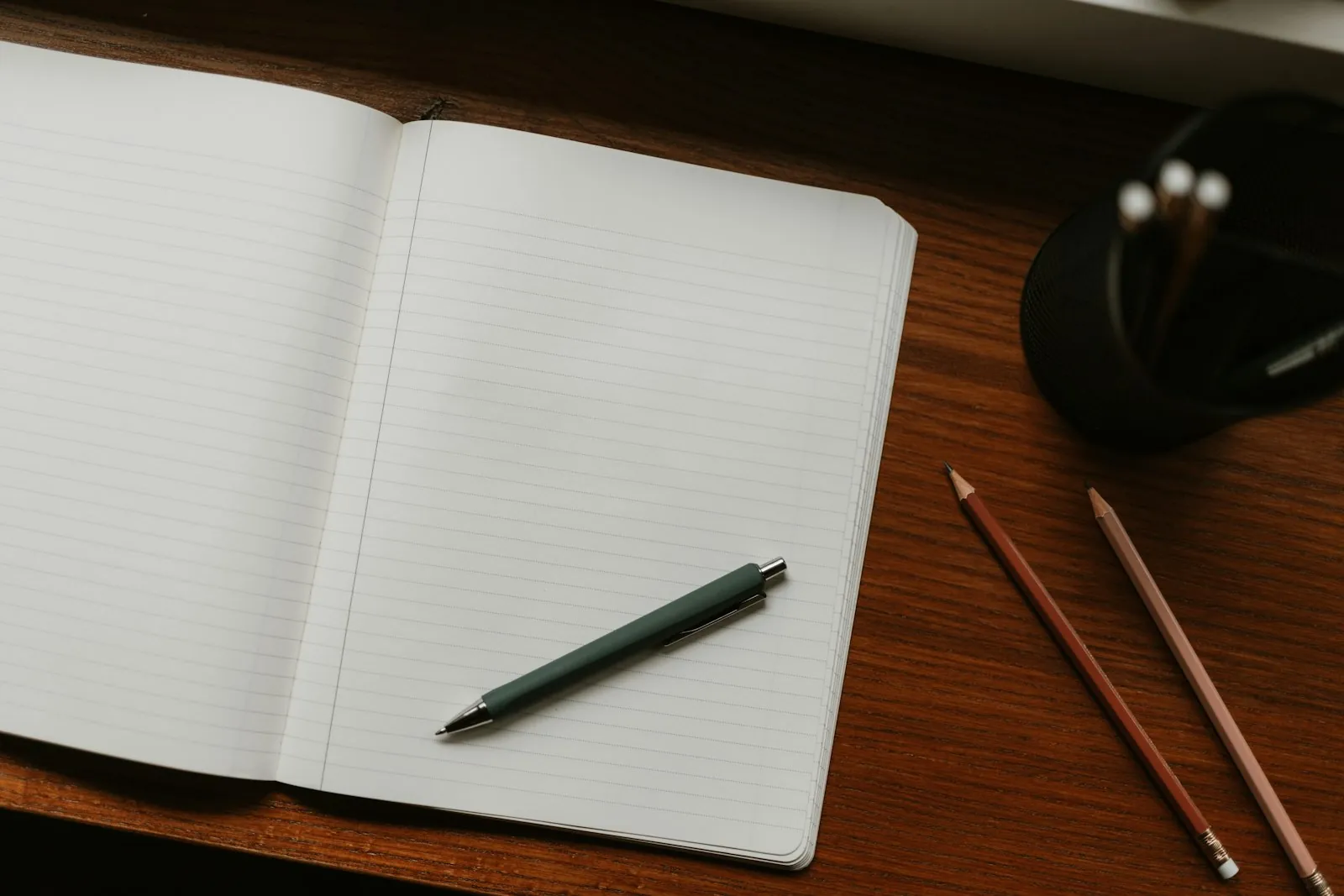 A notebook and pen on a desk, illustrating planning the order of appointments before travel.