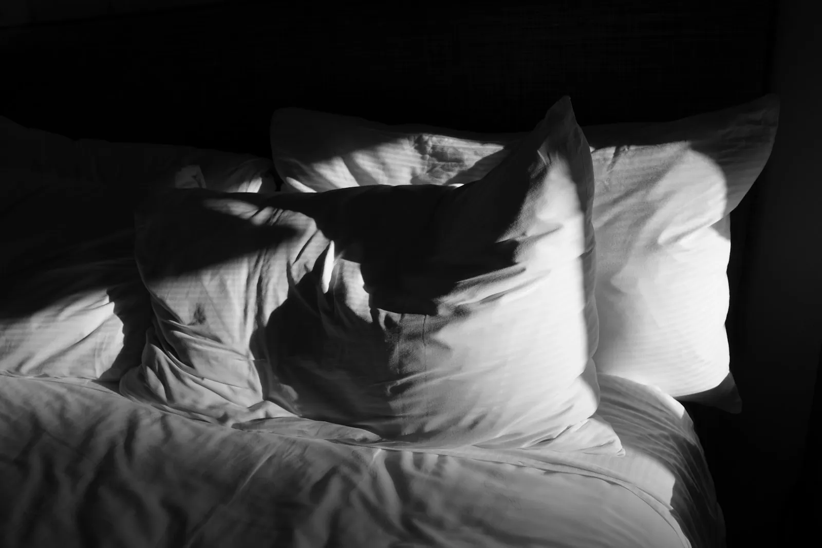 Pillows propped in a quiet bedroom, illustrating keeping the head elevated.